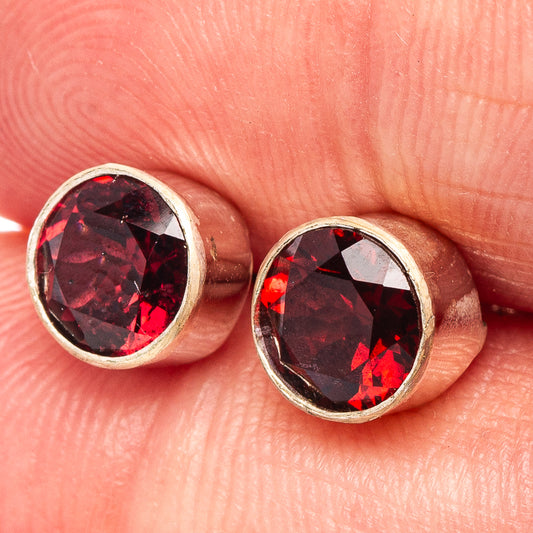 Round garnet stud earrings in .925 sterling silver with bezel-set red stones