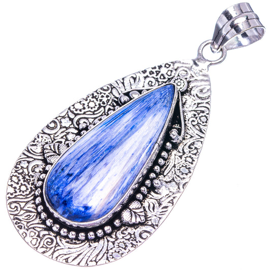 Ornate silver teardrop pendant with blue center stone and hanging bail