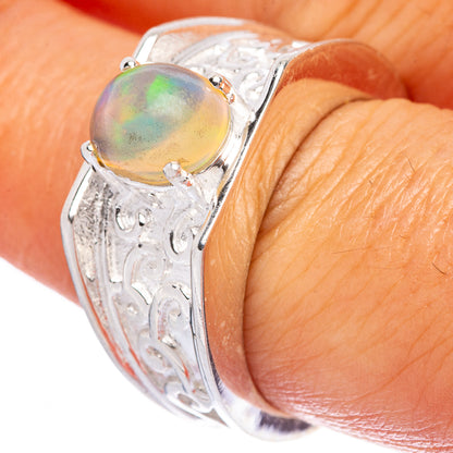Sterling silver opal ring on finger, oval iridescent stone set in engraved band
