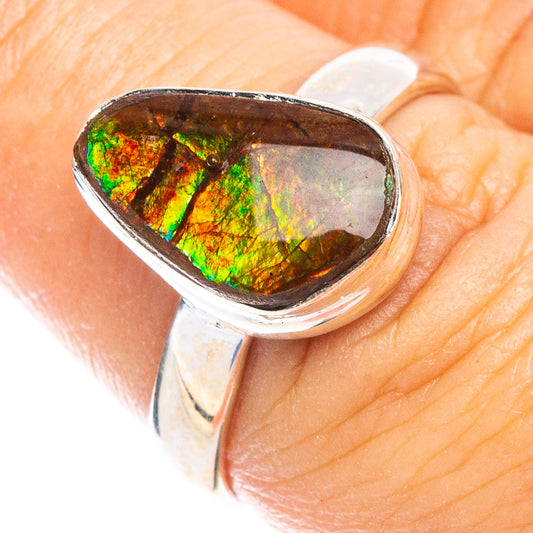 Rare ammolite ring in oval silver setting, iridescent green-orange gemstone.
