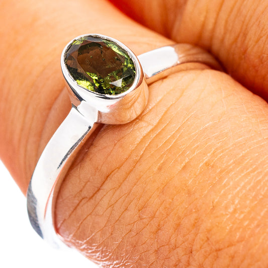 Sterling silver ring with round faceted green moldavite cabochon setting