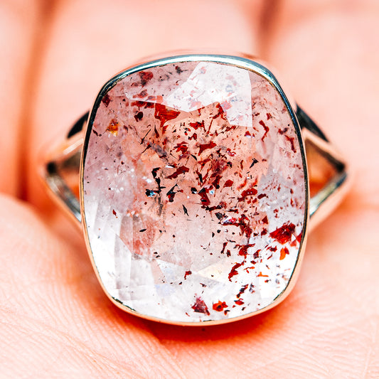 Centered view of oval lepidocrocite gemstone ring with silver-tone bezel and red flecked shimmer