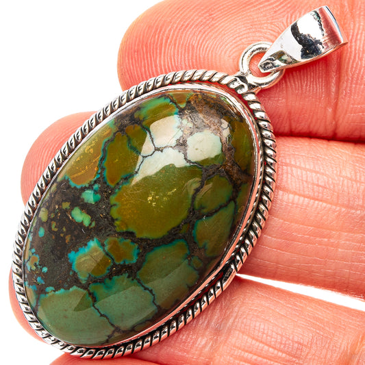 Oval turquoise cabochon pendant in .925 sterling silver with textured frame
