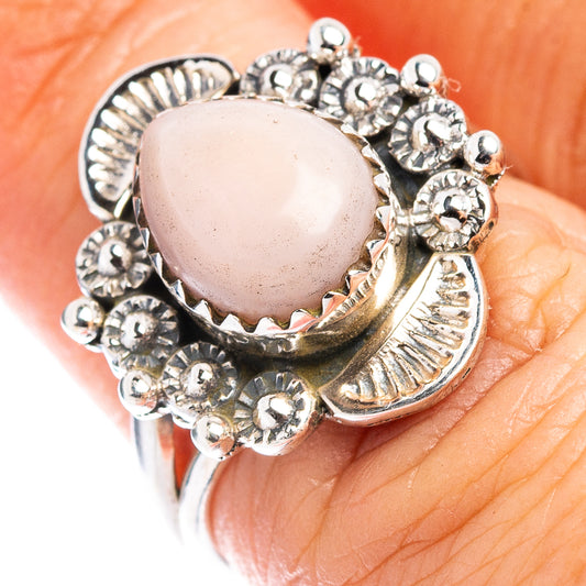 Sterling silver ring with pink oval stone and ornate floral arc setting