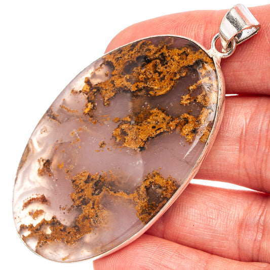 Close-up silver-plated oval agate pendant with dark brown and amber inclusions