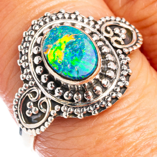 Sterling silver oval opal ring with ornate bezel and scalloped filigree setting