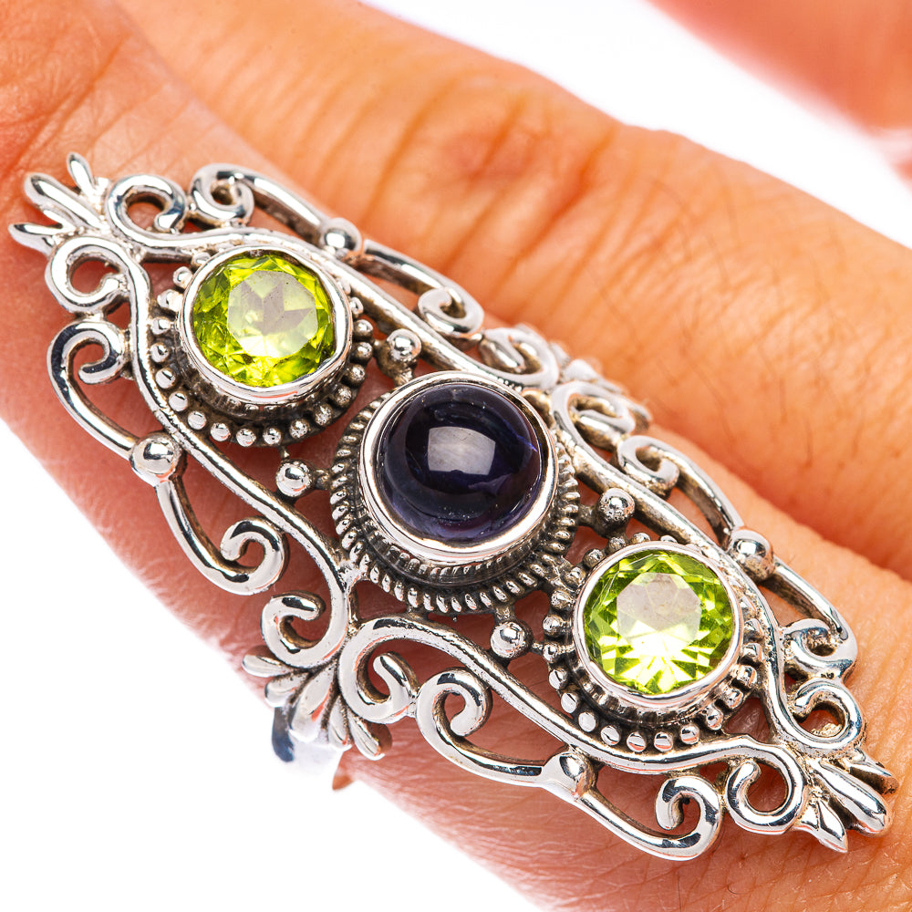 Sterling silver filigree ring with two green gemstones and a dark blue center stone