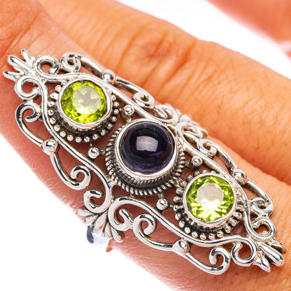 Sterling silver filigree ring with two green gemstones and a dark blue center stone