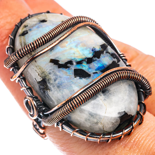 Oxidized copper wire-wrapped moonstone ring, oval cabochon with blue flashes and dark stones