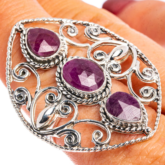 Sterling silver ring detail with three oval ruby-colored cabochon stones, twisted design