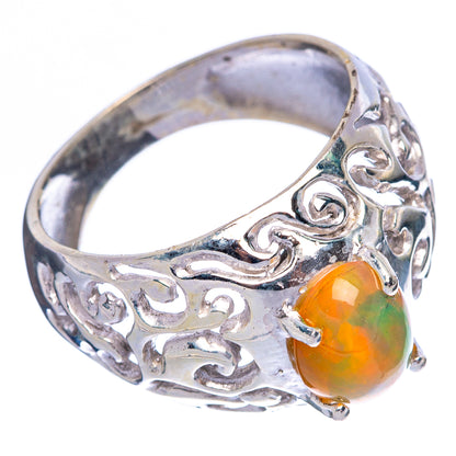 Sterling silver filigree ring with orange-green oval opal, decorative scrollwork setting.