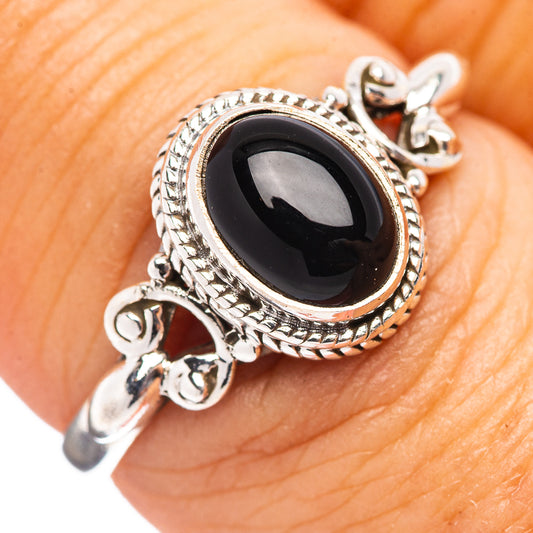 Silver ring with oval black onyx center and ornate rope edge setting