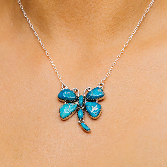 Blue turquoise butterfly pendant necklace on silver chain, close-up