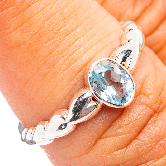 Sterling silver blue topaz ring with oval gemstone on finger, close-up