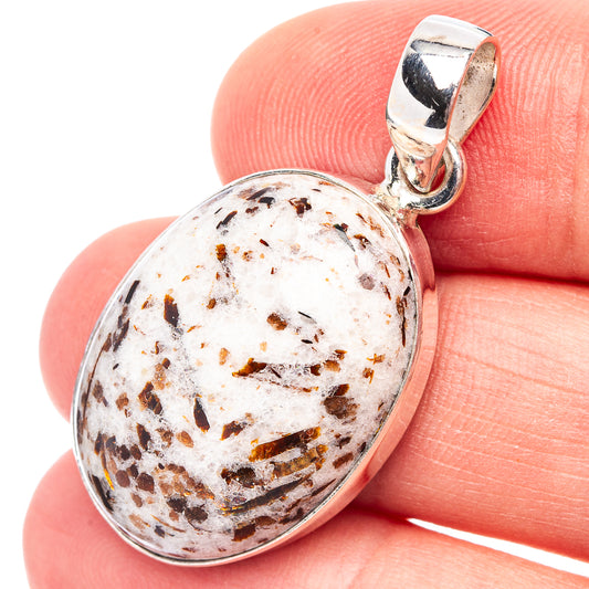 Astrophyllite pendant in oval silver bezel with speckled white gemstone and bail