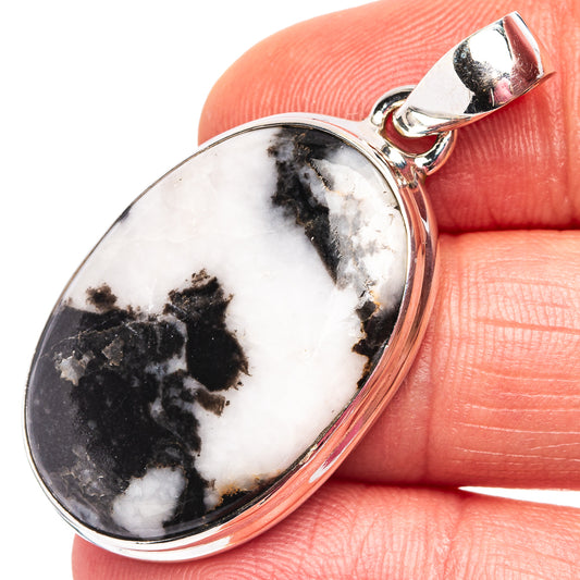 Oval white-and-black stone pendant in .925 sterling silver bezel with bail loop