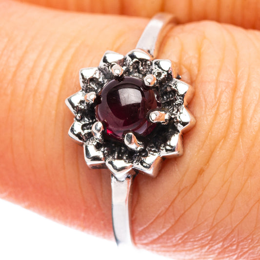 Dainty sterling silver ring with dark red garnet center and sparkling halo of stones