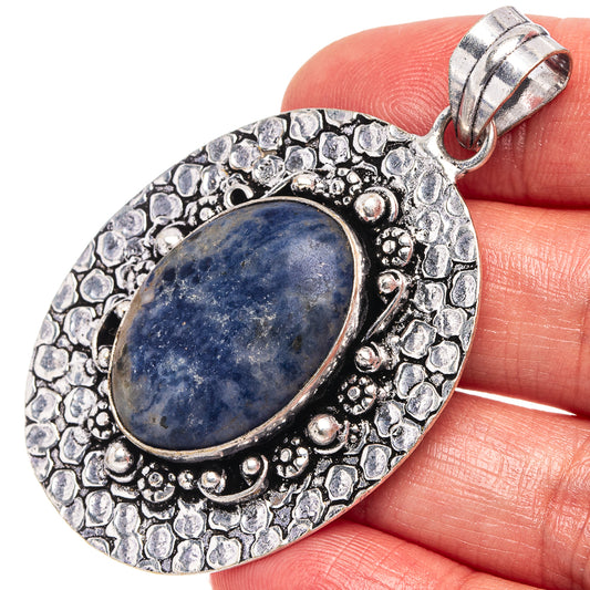 German silver sodalite pendant with textured oval frame, blue cabochon, hinged bail