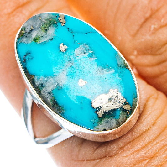 Oval turquoise cabochon ring with sterling silver bezel, speckled matrix and small gem inlay
