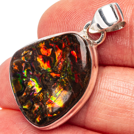 Sterling silver ammolite pendant close-up, fiery rainbow iridescence on dark teardrop
