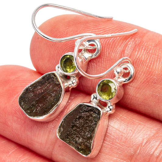 Close-up of sterling silver earrings with green round stone and dark irregular charms