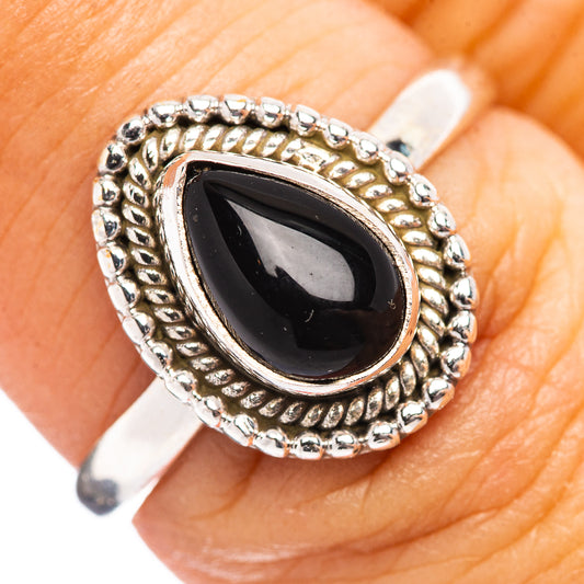 Sterling silver onyx ring close-up: bezel-set teardrop-shaped dark stone, beaded edge