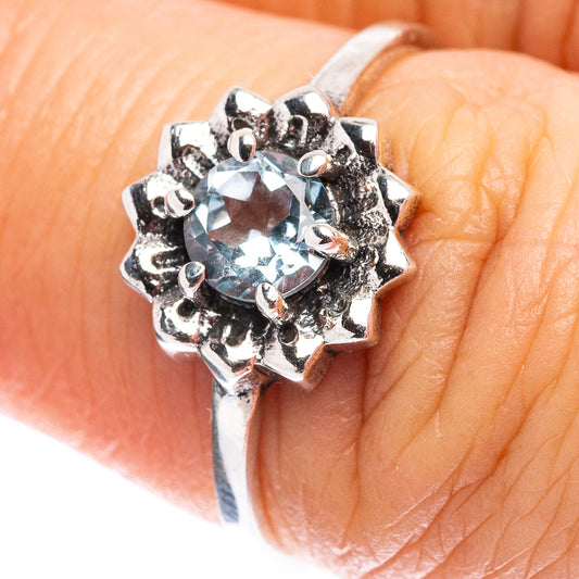 Silver ring with round light-blue topaz-style gemstone and ornate prong setting
