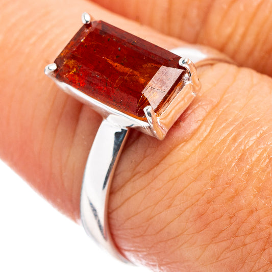 Sterling silver ring with orange-red rectangular gemstone and four prongs