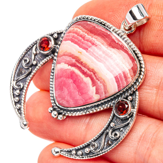 Pink rhodochrosite teardrop pendant in .925 sterling silver with red garnet side accents