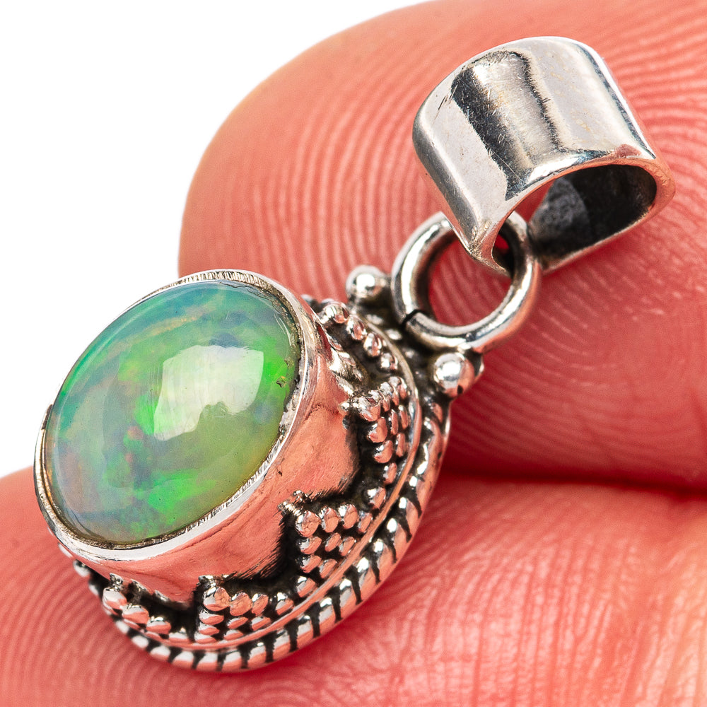 Oval opal pendant in sterling silver with ornate carved edge and loop bail