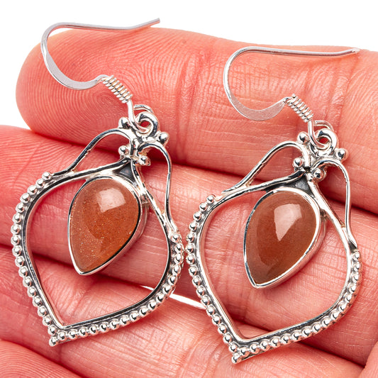 Peach moonstone drop earrings, oval cabochon in silver heart frame with beaded border