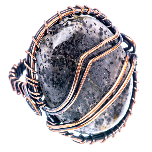 Oxidized copper wire-wrap ring with oval dark stone framed by stacked loops