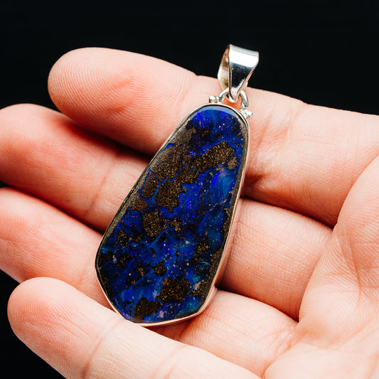 Sterling silver pendant with oval teardrop blue boulder opal gemstone, close-up