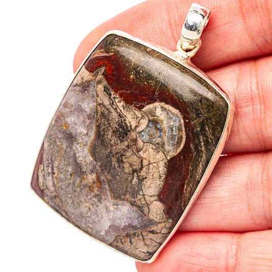 Sterling silver pendant with mottled rhyolite stone and round bail, textured bezel