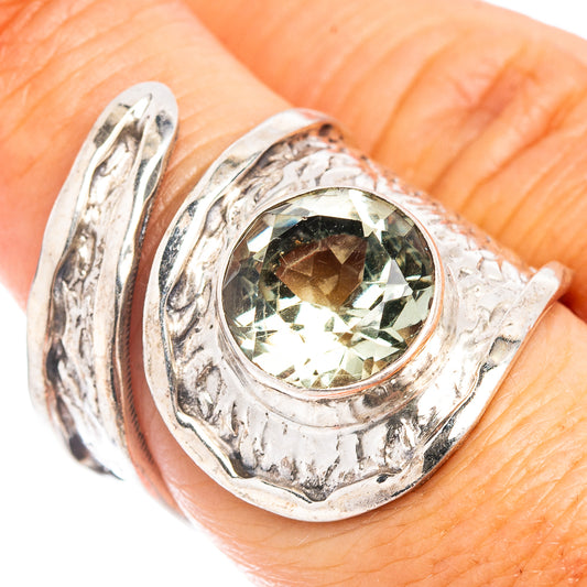Sterling silver ring with oval green amethyst center, engraved swirls around the bezel