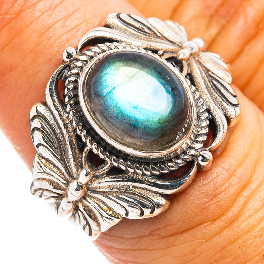 Sterling silver labradorite cabochon butterfly ring on finger, oval blue-green flash.