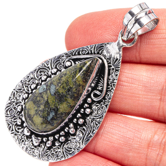 Teardrop pendant with green-yellow stone, silver-tone filigree, hinged bail