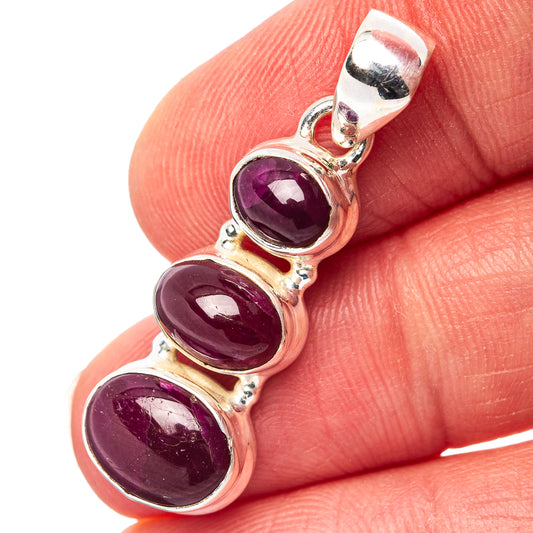 Sterling silver ruby pendant with three oval purple stones, close-up on bail