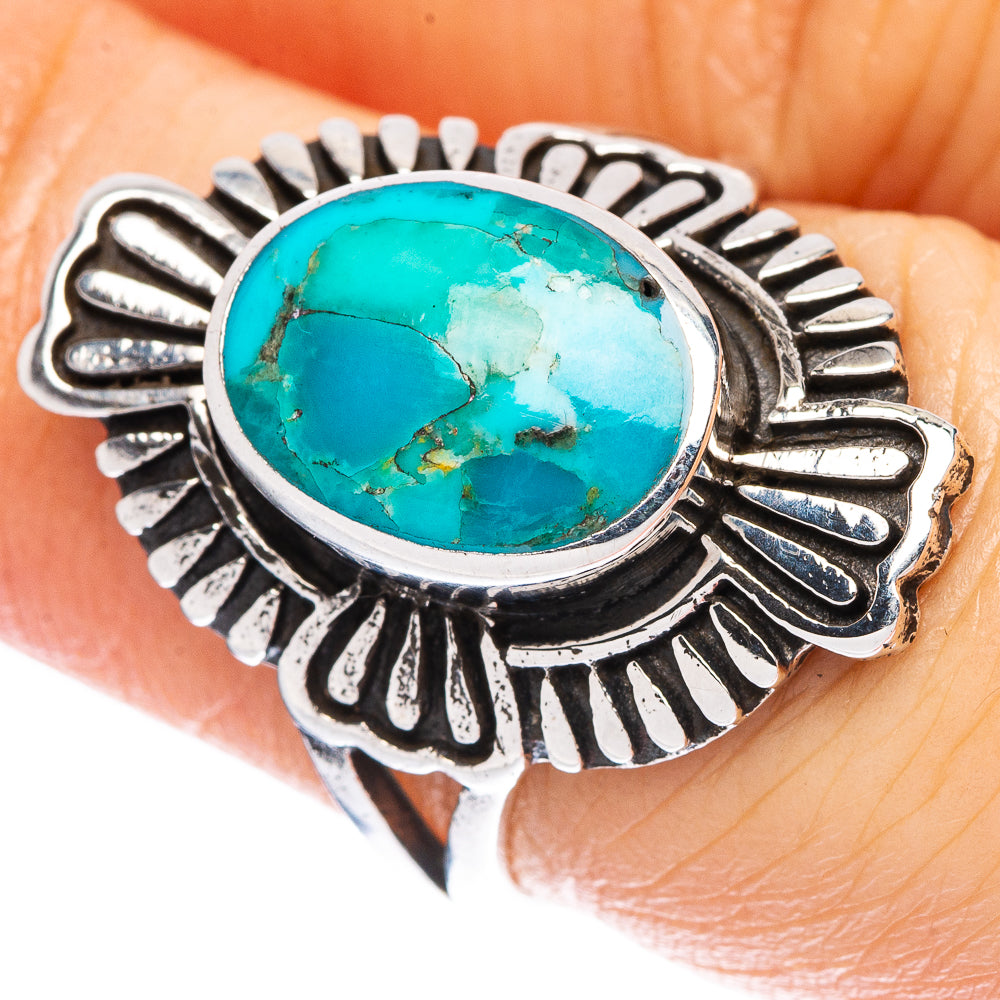 Turquoise cabochon ring with silver sunburst bezel on an oval setting