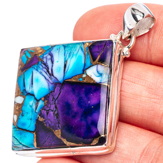 Turquoise and purple gemstone pendant, silver bail and bail loop; close-up on hand