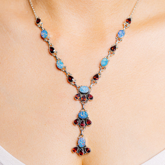 Sterling silver gemstone necklace with blue opal-like stones and red garnet accents
