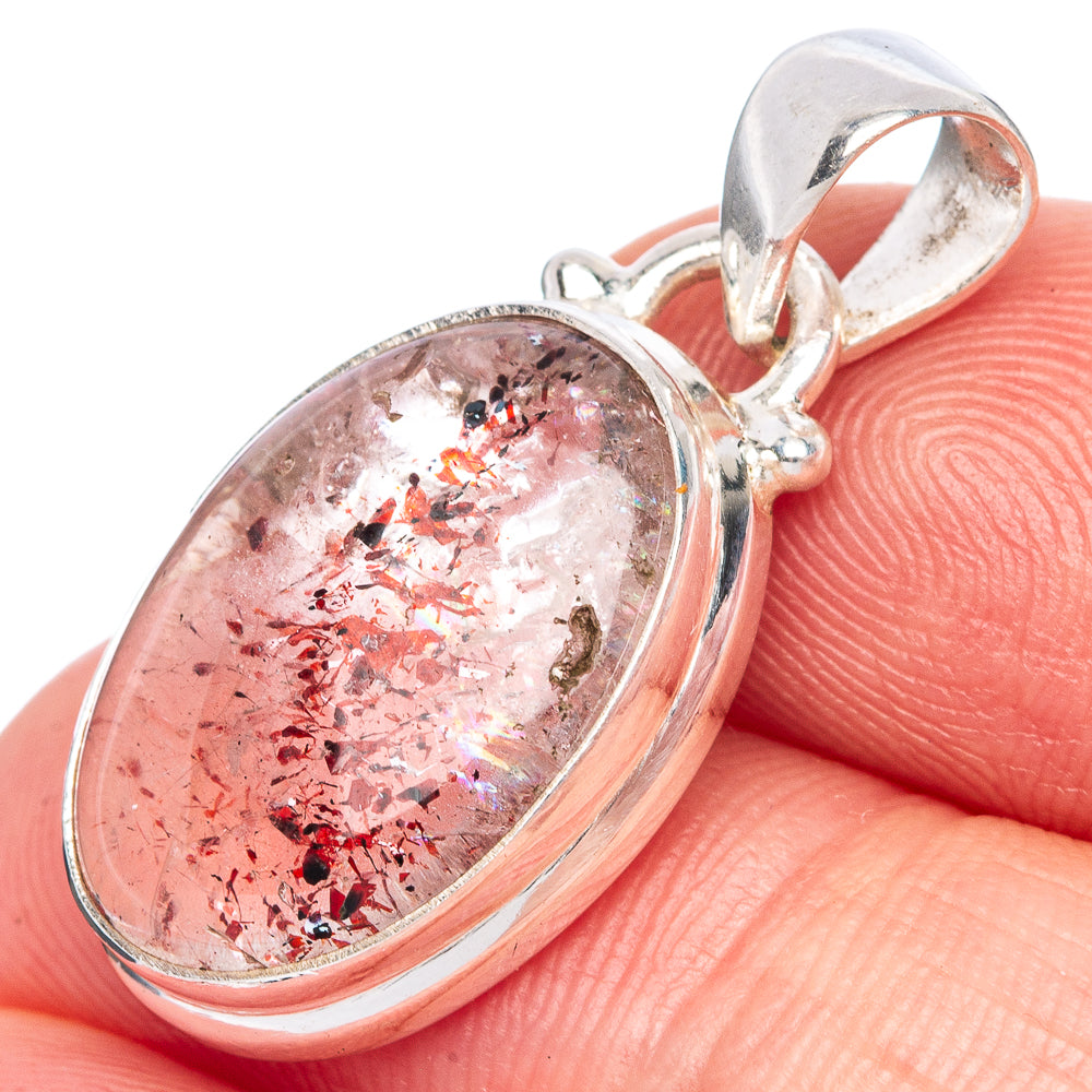 Sterling silver bezel-set oval pendant with red crystal inclusions close-up