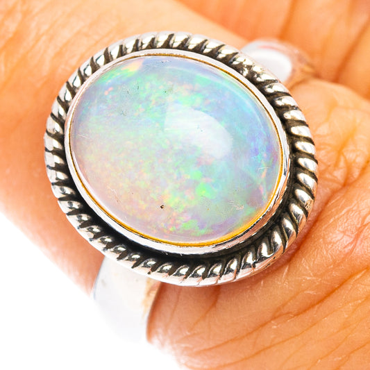 Sterling silver opal ring with round bezel, rope edge, iridescent light opal