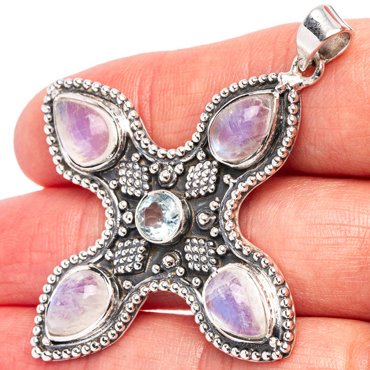 Sterling silver star-shaped pendant with iridescent moonstone cabochons and blue topaz center
