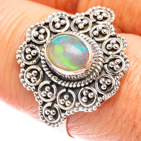 Heart-shaped sterling silver ring with oval green opal centerpiece and filigree details