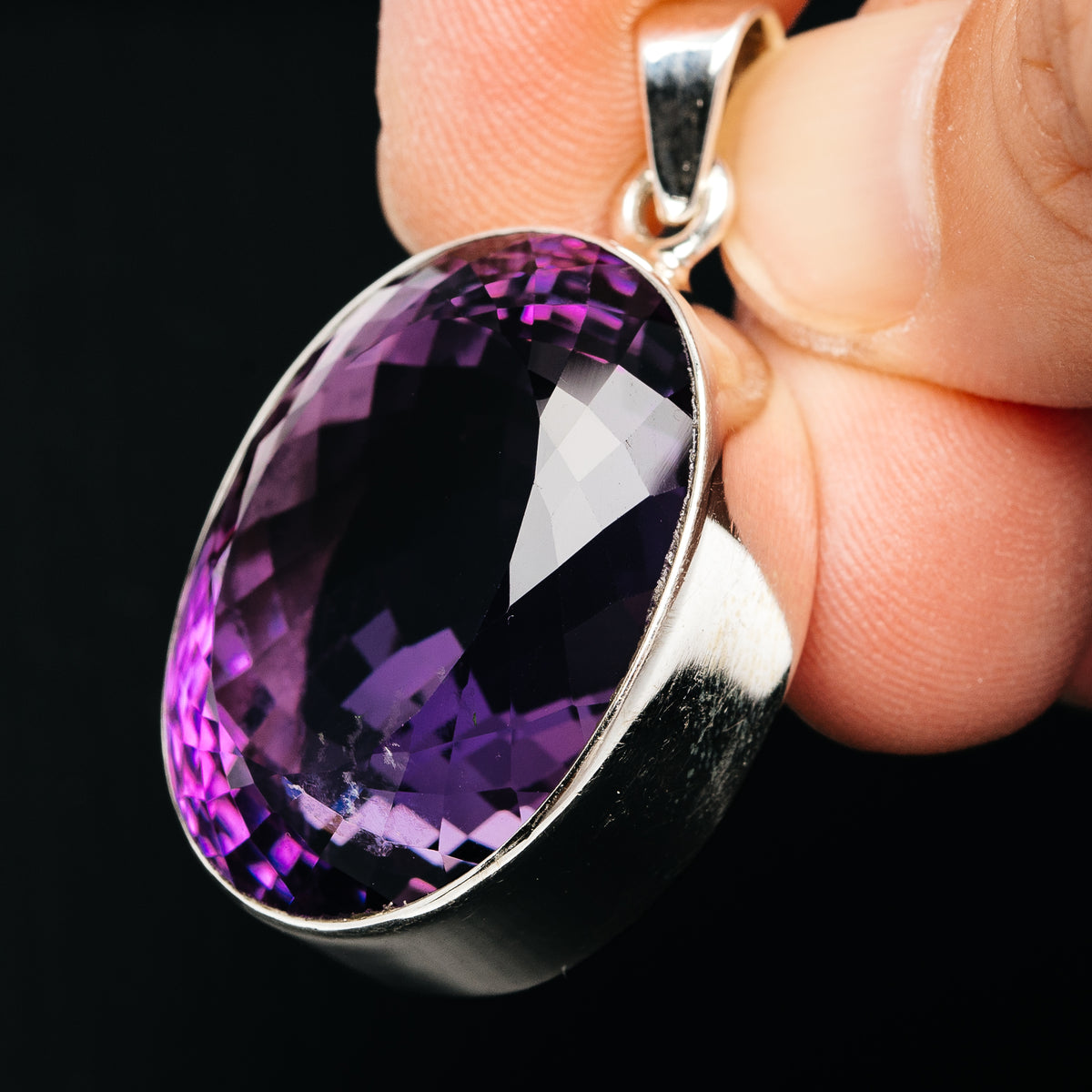 Side view of oval faceted amethyst pendant with .925 sterling silver bail