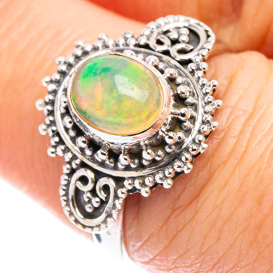 Sterling silver opal ring with oval green-orange Ethiopian opal centerpiece