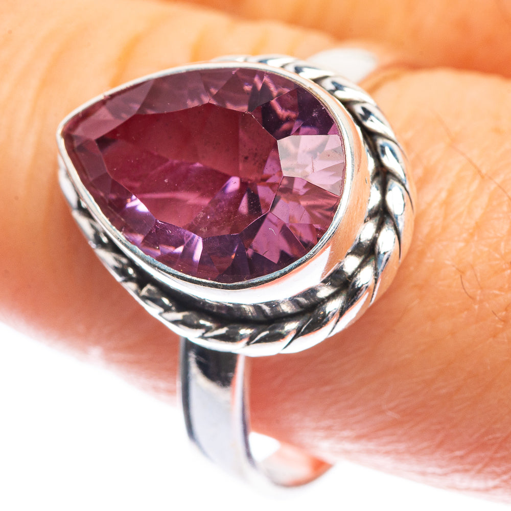 Silver ring with large oval faceted purple gemstone in twisted bezel setting