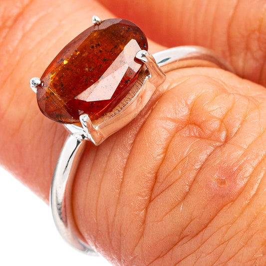 Orange kyanite ring on finger, oval gemstone with four-prong sterling silver setting