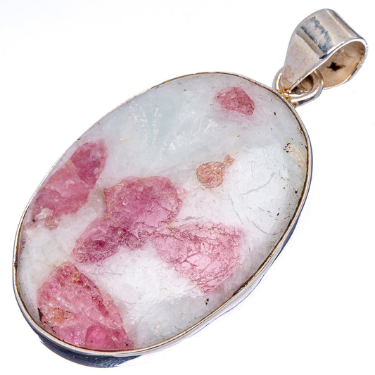 Oval tourmaline-in-quartz pendant showing pink crystal inclusions in clear stone.
